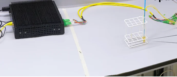 Optical interrogator connected by optical fibers to a fiber sensor in a sample tube